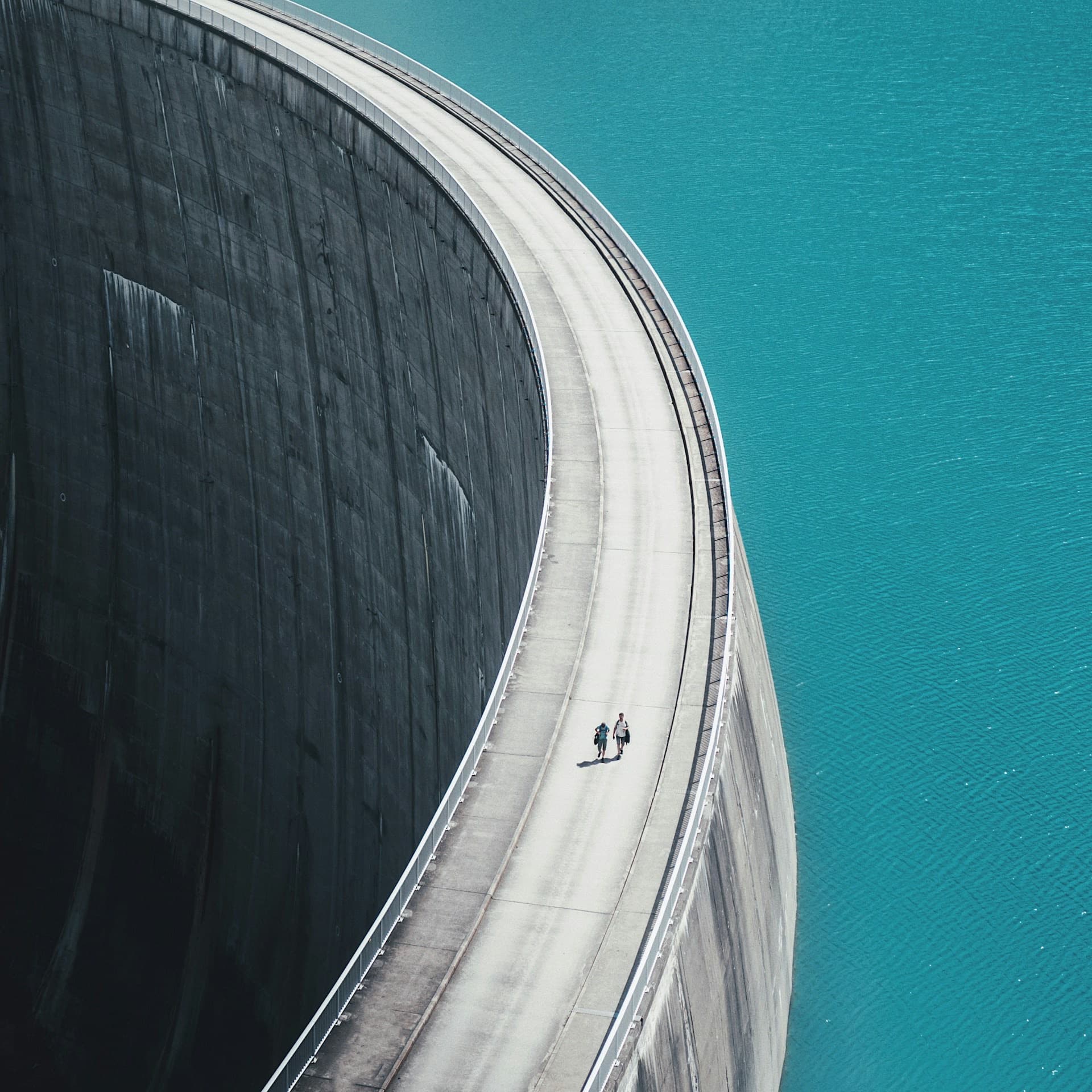 Curved dam wall between a reservoir and open water