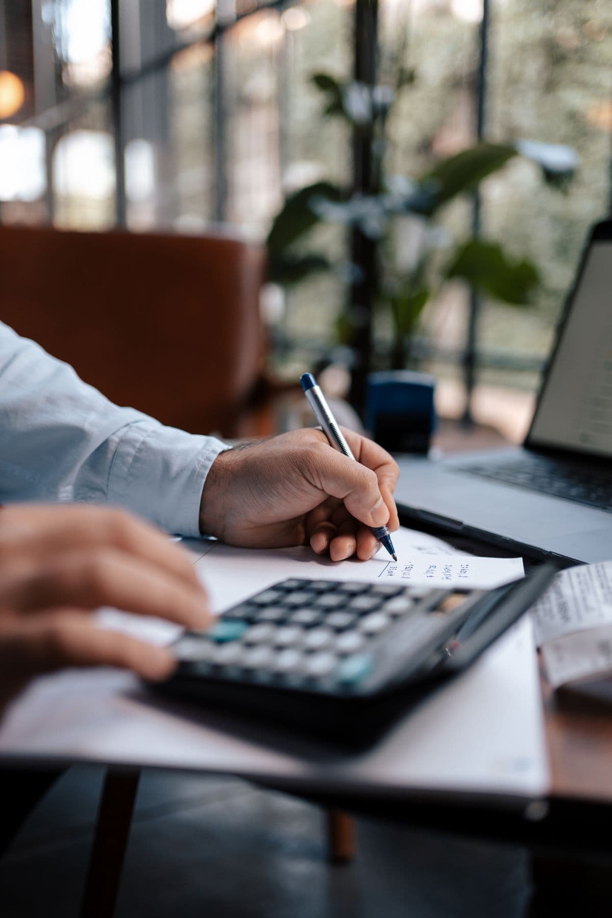 Analyst working through figures with a calculator and pen
