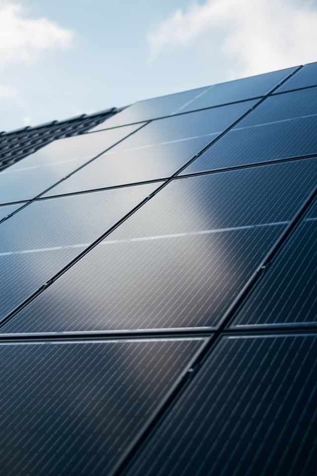 Close-up of solar panel modules under a bright sky
